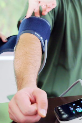 TR_Stock Photos_11 07 25-46 Healthcare professional placing a blood pressure cuff on a patient’s arm while using a digital blood pressure monitor in a medical detox program